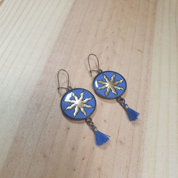 Boucles d'oreille pendantes soleil dor&eacute; sur fond bleu