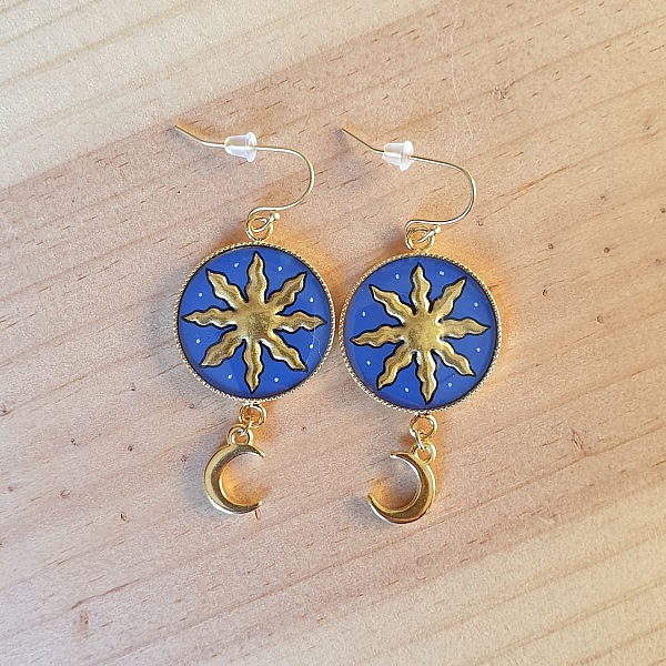 Boucles d'oreilles pendantes dorées motif soleil et lune médiéval.