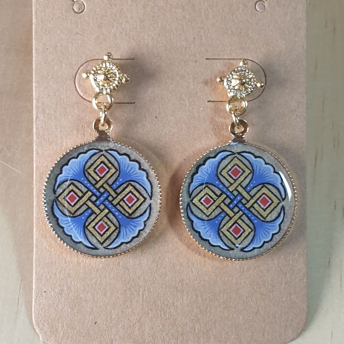 Pendientes luminosos con palmetas rojas o azules y entrelazado dorado