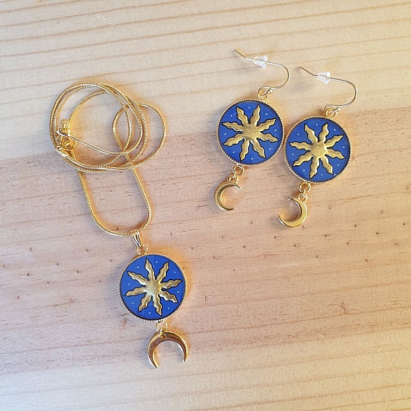 Parure collier et boucles d'oreilles soleil et lune dorés.