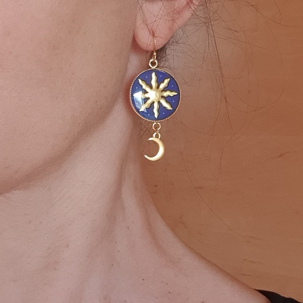 Boucles d'oreilles pendantes artisanales motif soleil et lune dorés.