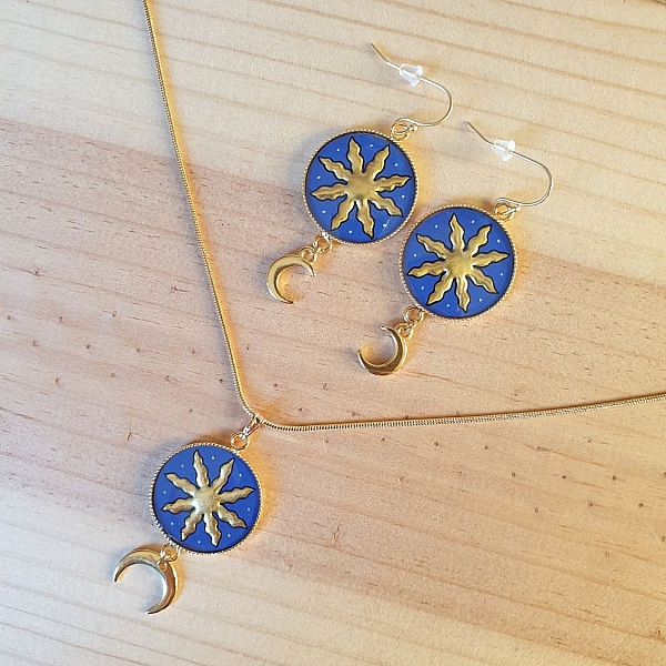 Parure bijoux artisanaux avec soleil et lune dorés.