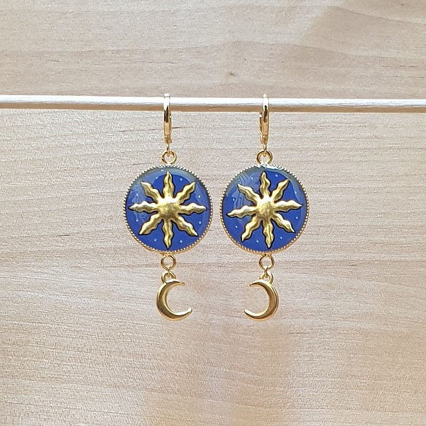 Boucles d'oreilles pendantes artisanales avec motifs soleil et lune.