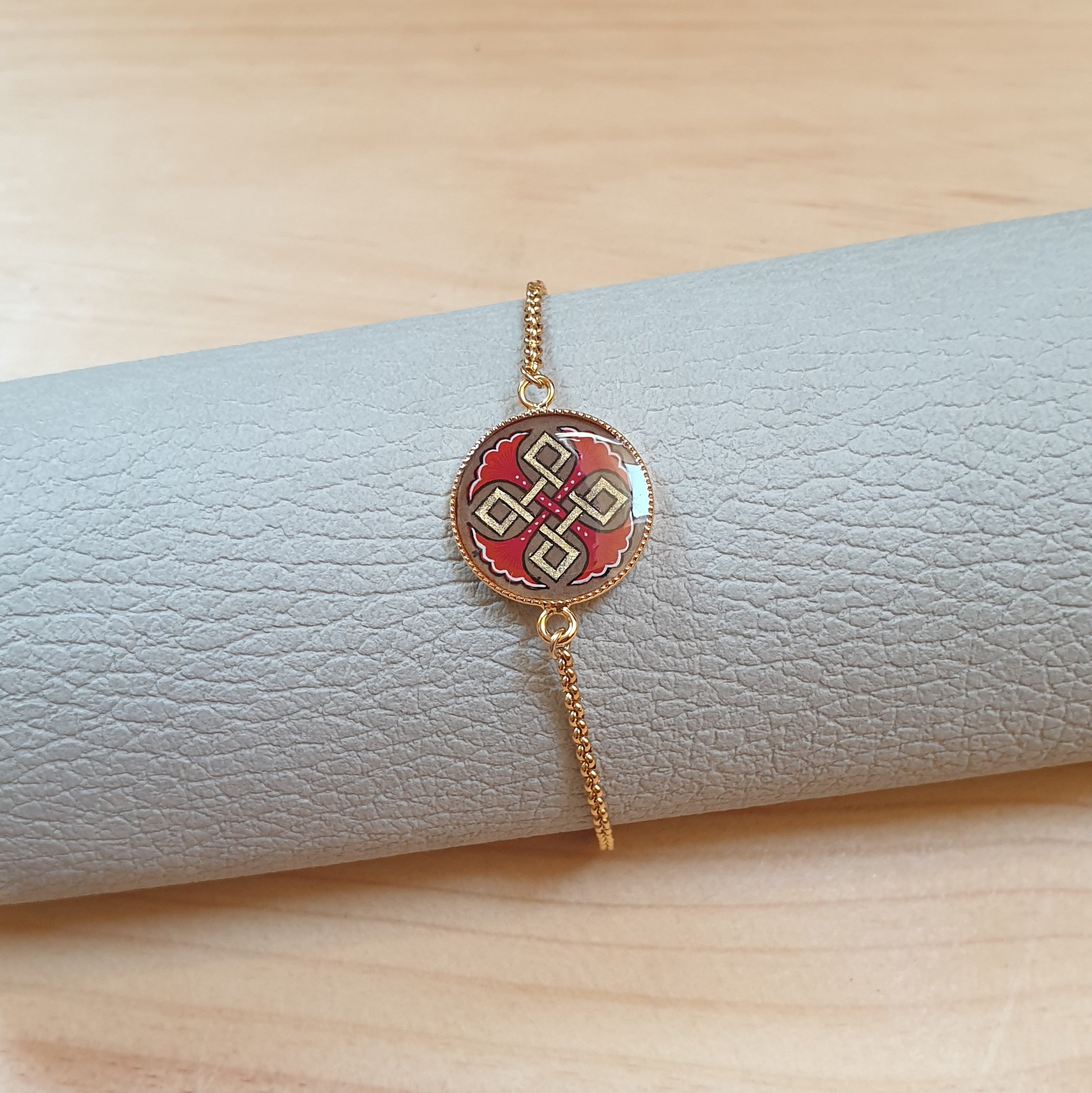 Bracelet r&eacute;glable entrelacs or et palmettes rouges ou bleues