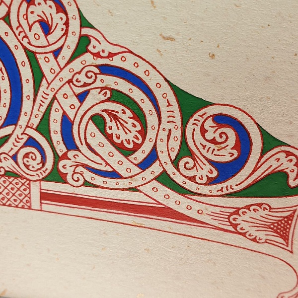 Lettre F enluminée style roman avec passe-partout rouge.