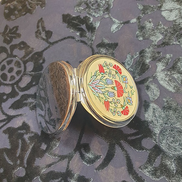 Miroir de sac avec enluminure florale ottomane sur fond doré.